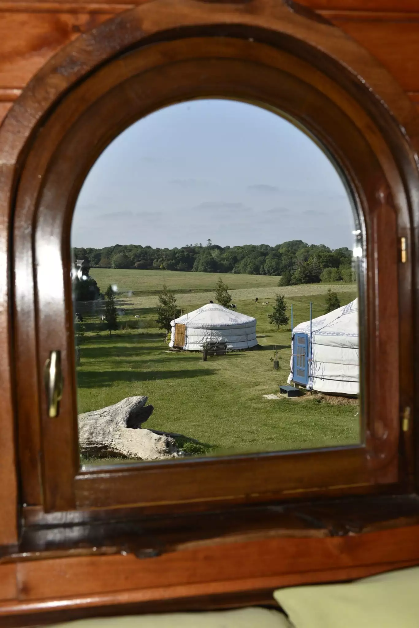 Les yourtes au travers de la fenêtre de la roulotte Finistère roulotte en bretagne : vue de la chambre